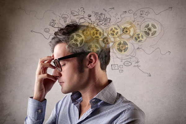buisness person thinking, with mechanical cogs and doodles superimposed via graphics over the image.